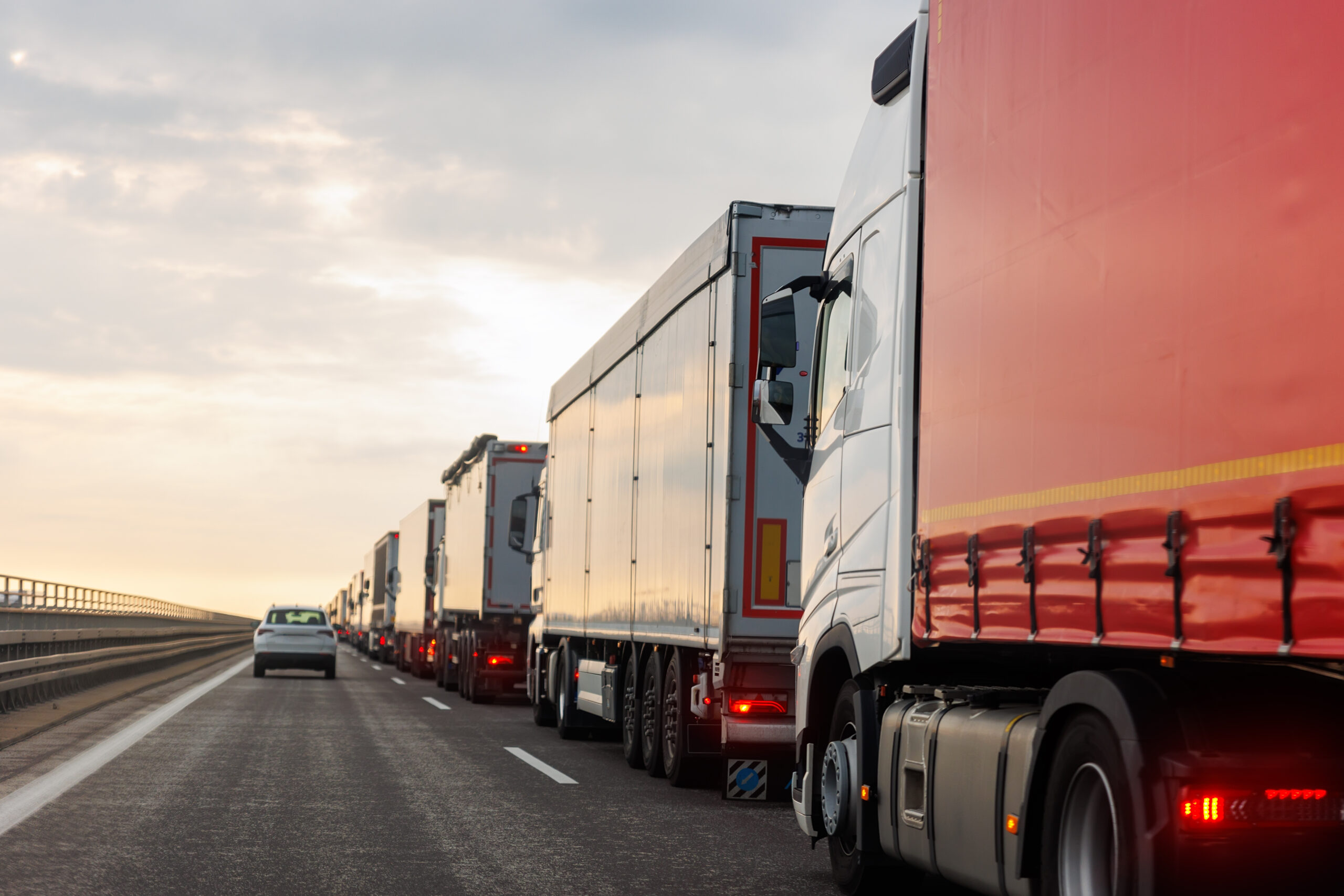 Queue of Trucks on Ukraine-Poland Border traffic jam at Sunset During Protest Roadblock. Business agricultural Logistics blockade action. Cargo lorry semi-trailers stuck